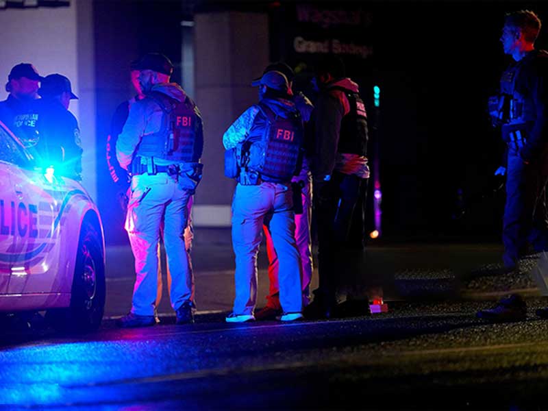 FBI and police officers responding to a night emergency scene.