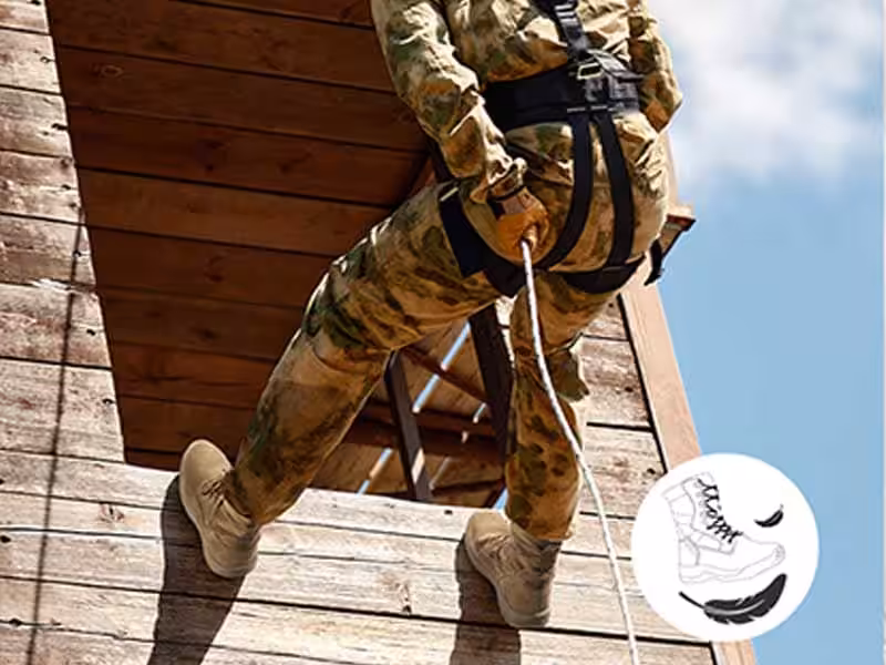 A person wearing tactical boots is rappelling down.