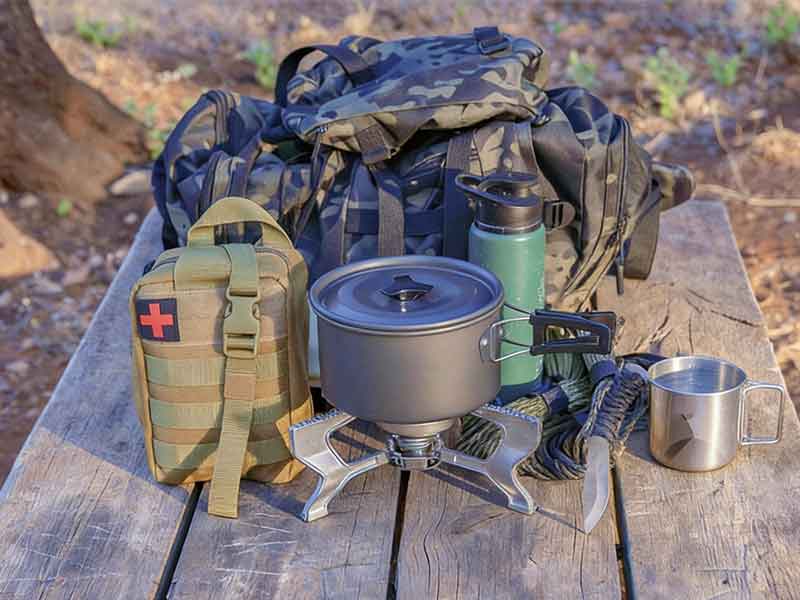 Outdoor camping survival kit with tactical backpack, cooking gear and emergency equipment