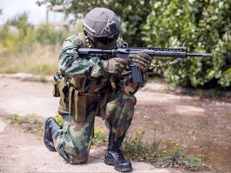 A soldier wearing tactical boots and holding a gun.