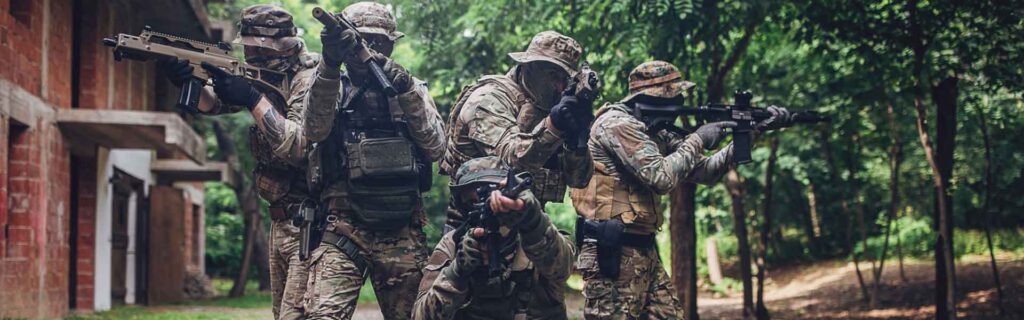 SONICE tactical team in camouflage uniforms training in forest with tactical gear