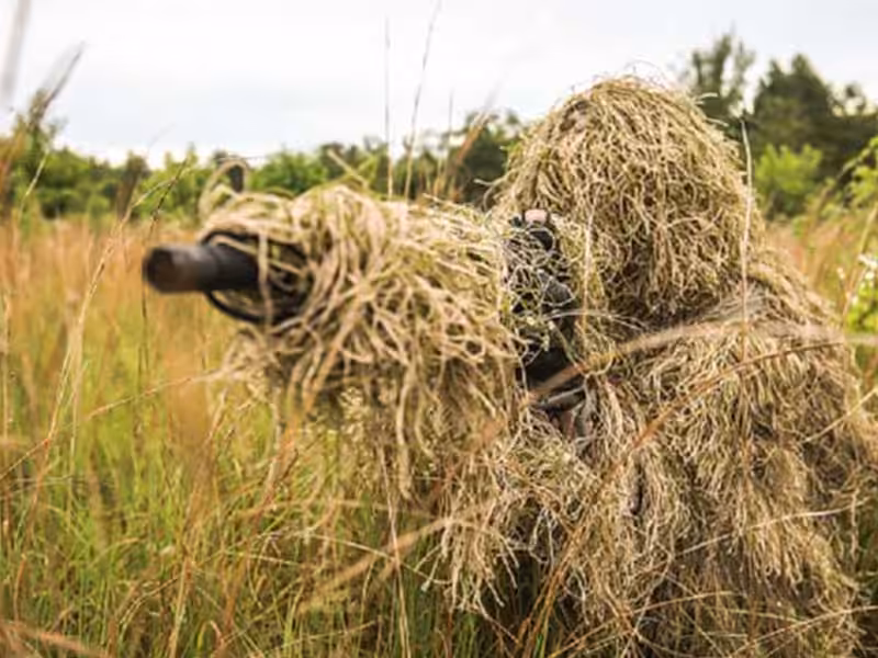 A person wearing a ghillie suit